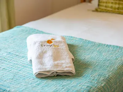 a white towel sitting on top of a bed at Sunshine House by Stay ici Algarve Holiday Rental in Albufeira