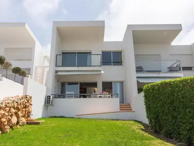 a white house with a green lawn in front of it at Serenity 09 House by Stay ici Algarve Holiday Rental in Albufeira