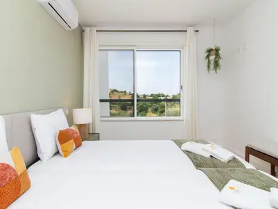 two beds in a room with a window at Serenity 09 House by Stay ici Algarve Holiday Rental in Albufeira