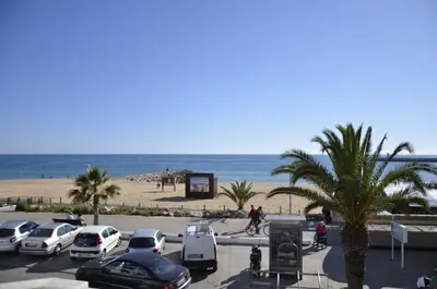 a parking lot with cars parked next to the beach at Sea Blue - Frente ao Mar in Quarteira