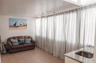 a living room with a couch in front of a window at Sea Blue - Frente ao Mar in Quarteira