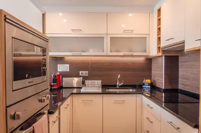 a kitchen with white cabinets and a sink at Sea Blue - Frente ao Mar in Quarteira