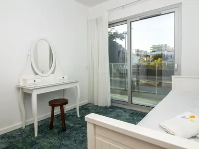 a white bedroom with a dressing table and a mirror at Green 3 Apartment by Stay ici Algarve Holiday Rental in Albufeira
