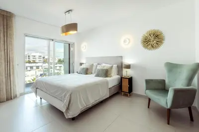 a balcony with chairs and a table and some windows at Penthouse Isabela VistaMar - Rooftop & Jacuzzi in Albufeira