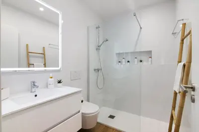 a white bathroom with a shower and a sink at Downtown Lux Apartment in Faro