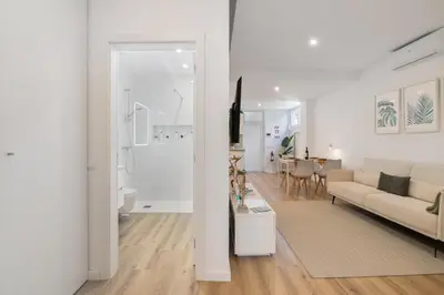 a white living room with a couch and a table at Downtown Lux Apartment in Faro