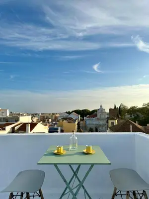 a table on a balcony with a view of the city at Downtown Lux Apartment in Faro