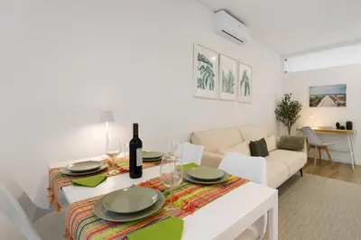 a white living room with a table and a couch at Downtown Lux Apartment in Faro
