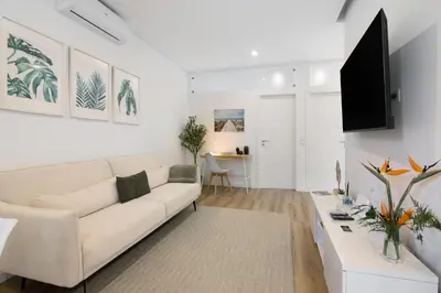 a living room with a white couch and a table at Downtown Lux Apartment in Faro
