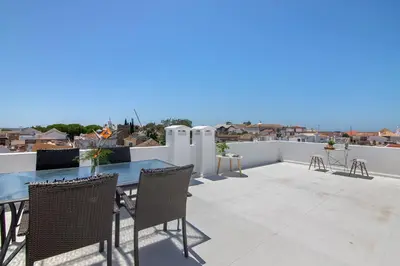 a patio with a blue table and chairs on a roof at Downtown Lux Apartment in Faro