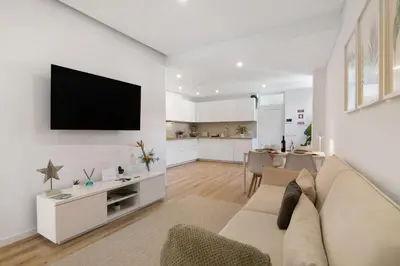 a living room with a couch and a tv on a wall at Downtown Lux Apartment in Faro