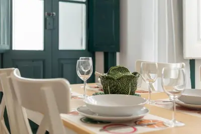 a dining table with wine glasses and a plate on it at Casa Dona Vitória in Faro