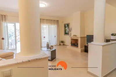 a living room with a column and a tv at #297 Espaçosa Vivenda V5 by Home Holidays in Albufeira
