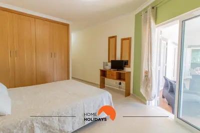 a bedroom with a bed and a tv and a window at #297 Espaçosa Vivenda V5 by Home Holidays in Albufeira