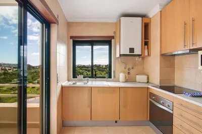 a kitchen with a sink and a large window at Sunrise Salgados Village in Galé