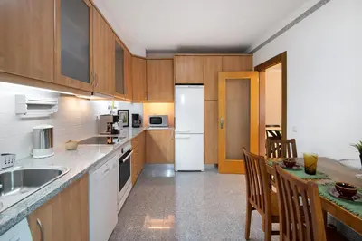 a kitchen with wooden cabinets and a white refrigerator at Apart Condomínio do Vale in Guia