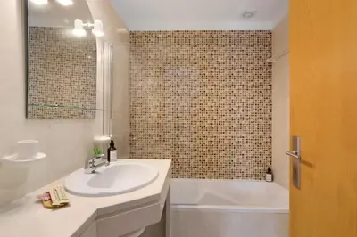 a bathroom with a sink and a toilet and a mirror at Apart Condomínio do Vale in Guia