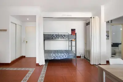a living room with a couch and a tv at Oura Beach Cozy Apartment in Albufeira