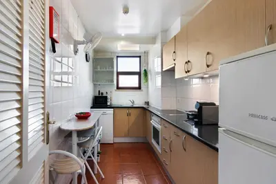 a small kitchen with a table and a refrigerator at Oura Beach Cozy Apartment in Albufeira