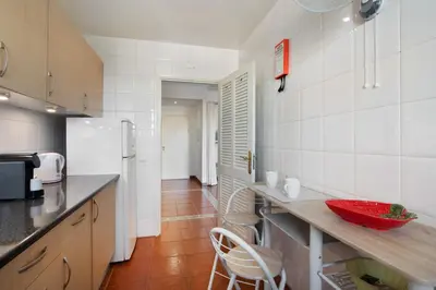 a kitchen with a counter and two chairs in it at Oura Beach Cozy Apartment in Albufeira