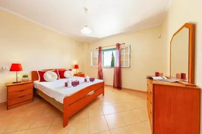 a bedroom with a bed and a dresser and a mirror at Villa Saona by Algarve Vacation in Albufeira