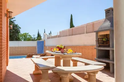 a patio with a table and chairs and a pizza oven at Villa Saona by Algarve Vacation in Albufeira