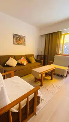 a living room with a couch and a table at Apartamento relaxante com terraço e próximo da praia, no 2º andar in Quarteira