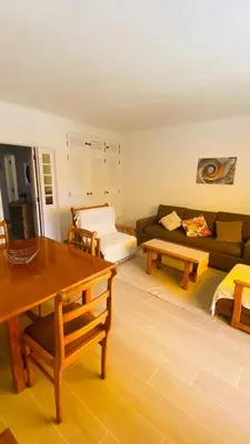 a living room with a couch and a table at Apartamento relaxante com terraço e próximo da praia, no 2º andar in Quarteira