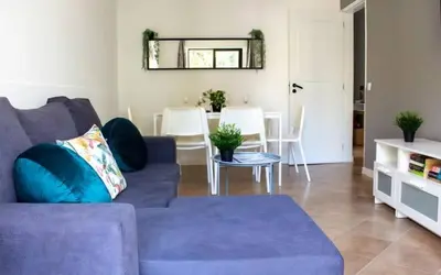 a living room with a blue couch and a table at Quarteira-Your Seaside Getaway in Quarteira