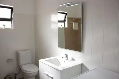 a white bathroom with a toilet and a sink at Quarteira-Your Seaside Getaway in Quarteira
