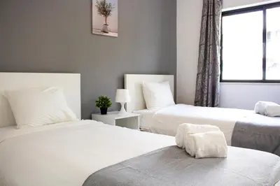 a bedroom with two beds and a window at Quarteira-Your Seaside Getaway in Quarteira