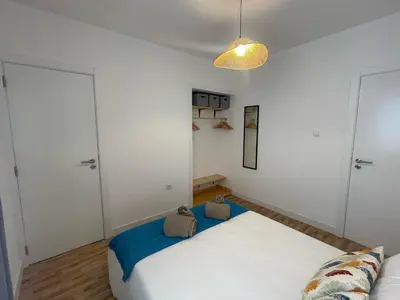 a bedroom with a large white bed and a lamp at Casa da Baixa in Faro