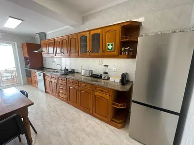 a kitchen with wooden cabinets and a stainless steel refrigerator at Casa da Baixa in Faro