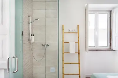 a bathroom with a shower with a glass door at Faro DAZ House by Get Your Stay in Faro