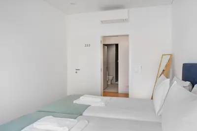 a white room with a bed and a mirror at Faro DAZ House by Get Your Stay in Faro