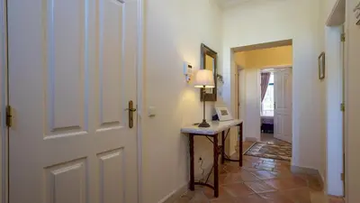 a hallway with a door and a table with a lamp at 3Br Apt-Quinta do Lago-Private Terrace in Quinta do Lago