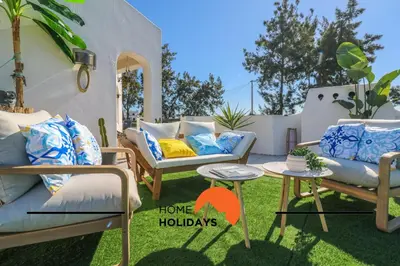 a patio with chairs and a table with a sign that says home holidays at #294 T2 Com Amplo Terraço by Home Holidays in Albufeira
