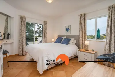 a bedroom with a bed and windows with the words home holidays at #294 T2 Com Amplo Terraço by Home Holidays in Albufeira