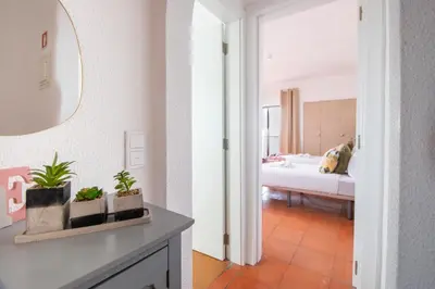 a bedroom with a bed and a table with potted plants at BeGuest Vila Magna Apartment in Albufeira