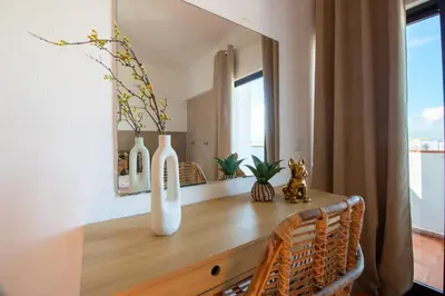 a table with two white vases and a mirror at BeGuest Vila Magna Apartment in Albufeira