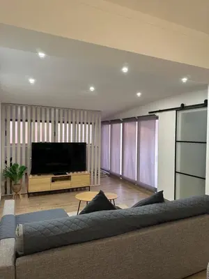 a living room with a couch and a flat screen tv at Beach, please! in Quarteira