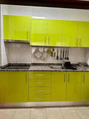 a kitchen with yellow cabinets and a sink at Beach, please! in Quarteira