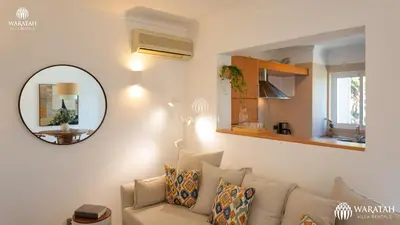 a living room with a couch and a mirror at Apartment Lamine in Loulé