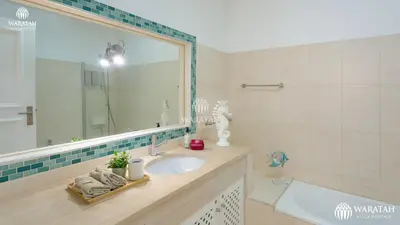 a bathroom with a sink and a mirror and a tub at Apartment Lamine in Loulé
