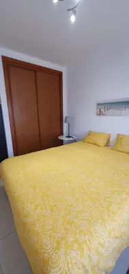a bedroom with a large bed with a yellow blanket at Alfamar e Falésia in Albufeira