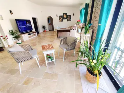 a living room with chairs and a table and a tv at Quinta Azul in Loulé