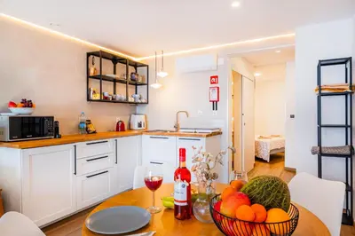 a kitchen with a table with a bowl of fruit at Sun&Sea in Albufeira