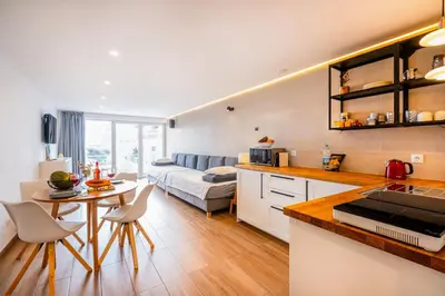 a kitchen and living room with a table and a couch at Sun&Sea in Albufeira