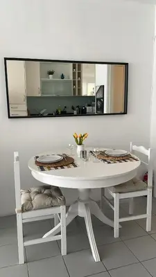 a white table with two chairs and a mirror at Casa Ligia in Vilamoura