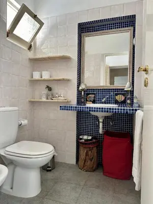 a bathroom with a toilet and a sink and a mirror at Balaia Gardens in Albufeira in Albufeira